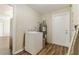 Utility room with a washing machine, water heater and access to the backyard through an exterior door at 5822 Flori Ln, Orlando, FL 32808