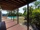 Covered wooden deck overlooking a sparkling in-ground pool and a private, tree-lined backyard at 601 Blackstone Ave, Deltona, FL 32725
