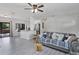 Open living area with gray vinyl flooring, neutral walls, ceiling fan, and slider doors at 601 Blackstone Ave, Deltona, FL 32725