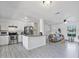 Bright open-concept kitchen and living area featuring white cabinets and gray vinyl flooring at 601 Blackstone Ave, Deltona, FL 32725