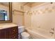 Well-lit bathroom with tiled tub, dark vanity, and a framed mirror; toilet in the corner at 6512 Swissco Dr # 1428, Orlando, FL 32822