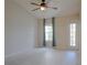 Bright bedroom features a ceiling fan, light-colored tile floors, and natural light through a window and door at 6512 Swissco Dr # 1428, Orlando, FL 32822