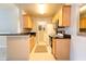 Functional kitchen featuring wood cabinets, granite countertops, and a view of the laundry area at 6512 Swissco Dr # 1428, Orlando, FL 32822