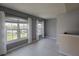 Bright living room featuring gray walls, gray tile floors, and large windows with sheer curtains at 6512 Swissco Dr # 1428, Orlando, FL 32822