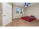 Cozy bedroom with comfortable carpet flooring, a blue ceiling fan, and natural light from two windows at 6611 Time Square Ave # 103, Orlando, FL 32835