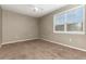 Inviting bedroom with plush carpet, neutral walls, and natural light streaming through a large window at 6611 Time Square Ave # 103, Orlando, FL 32835