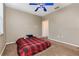 Bright bedroom featuring neutral walls, carpet, and a blue fan with a window providing natural light at 6611 Time Square Ave # 103, Orlando, FL 32835