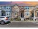 Two-story townhome showcasing colorful exteriors, covered porches, and black railings at 6611 Time Square Ave # 103, Orlando, FL 32835