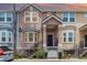 Charming two-story townhome with a covered porch, black railings, and colorful exterior paint at 6611 Time Square Ave # 103, Orlando, FL 32835