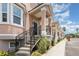 Close-up view of a two-story townhome with a covered porch, and black railings at 6611 Time Square Ave # 103, Orlando, FL 32835