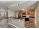 Open kitchen with wood cabinets, stainless steel appliances, and a breakfast bar overlooking the living area at 6611 Time Square Ave # 103, Orlando, FL 32835