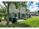 Townhome backyard featuring green lawn, patio, exterior with gray trim, and mature trees at 6636 S Goldenrod Rd # 116B, Orlando, FL 32822