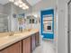Bright bathroom boasting double sinks, spacious vanity, white tile flooring, and vibrant blue accent wall at 6636 S Goldenrod Rd # 116B, Orlando, FL 32822