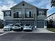 Two-story townhome featuring private balconies, gray exterior, and a two-car garage in a neighborhood setting at 6636 S Goldenrod Rd # 116B, Orlando, FL 32822