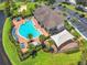 Aerial shot of a community pool and lounging area surrounded by lush landscaping and lake at 6636 S Goldenrod Rd # 116B, Orlando, FL 32822