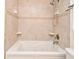 Bright bathroom featuring a soaking tub with tan tile surround and updated showerhead at 677 Post Oak Cir # 115, Altamonte Springs, FL 32701
