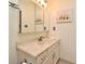 Bright bathroom with marble counter and vanity with matching cabinets and large mirror at 677 Post Oak Cir # 115, Altamonte Springs, FL 32701