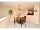 Bright dining area featuring a chandelier, a wooden table, and a view into the kitchen, great for entertaining at 677 Post Oak Cir # 115, Altamonte Springs, FL 32701