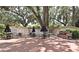 Exterior view of a building surrounded by large trees with outdoor seating and grills at 677 Post Oak Cir # 115, Altamonte Springs, FL 32701