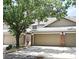 Inviting townhouse with neutral siding, attached garages, brick accents, and mature trees shading the facade at 677 Post Oak Cir # 115, Altamonte Springs, FL 32701