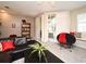 Cozy living room with black leather seating, plush carpet, and sliding glass door to a screened-in porch at 677 Post Oak Cir # 115, Altamonte Springs, FL 32701