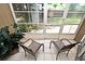 The screened patio features tile floors and two chairs overlooking the back yard at 677 Post Oak Cir # 115, Altamonte Springs, FL 32701
