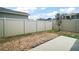 Backyard featuring a white fence for privacy, minimal grass, and a small tree at 7054 Cruz Ct, Lakeland, FL 33813