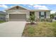 Charming single-story home with a neutral color palette, a well-manicured lawn, and attached garage at 7054 Cruz Ct, Lakeland, FL 33813