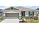 Charming single-story home with a neutral color palette, a well-manicured lawn, and attached garage at 7054 Cruz Ct, Lakeland, FL 33813