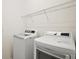Laundry room with a new washer and dryer, and overhead shelving, designed for efficient laundry at 7054 Cruz Ct, Lakeland, FL 33813