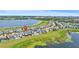 A high-angle view of a lakeside neighborhood showcasing community and nearby city at 7500 Alpine Butterfly Ln, Orlando, FL 32819