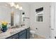 Bright bathroom featuring navy vanity with granite countertop, modern fixtures, and a walk-in shower at 7500 Alpine Butterfly Ln, Orlando, FL 32819