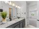 Bathroom featuring double granite vanity, large mirror and access to bedroom at 7500 Alpine Butterfly Ln, Orlando, FL 32819