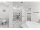 Bright bathroom showcasing a glass-enclosed shower, toilet, and large neutral tile flooring at 7500 Alpine Butterfly Ln, Orlando, FL 32819