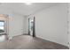 Minimalist bedroom with neutral carpet, a window, and an adjacent doorway providing access to another area at 7500 Alpine Butterfly Ln, Orlando, FL 32819