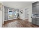 Dining area boasts ample natural light, wood floors, and stylish gray cabinetry with granite countertops at 7500 Alpine Butterfly Ln, Orlando, FL 32819
