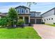Charming two-story home with a beautifully landscaped yard and a brick driveway at 7500 Alpine Butterfly Ln, Orlando, FL 32819