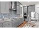 Modern kitchen featuring gray cabinetry, granite countertops, mosaic backsplash, and built-in stainless steel appliances at 7500 Alpine Butterfly Ln, Orlando, FL 32819