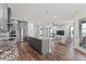 Open-concept kitchen with gray cabinets, granite countertops, and stainless steel appliances flowing into the living area at 7500 Alpine Butterfly Ln, Orlando, FL 32819