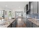 Bright kitchen showcasing gray cabinets, granite countertops, mosaic backsplash, and stainless steel appliances at 7500 Alpine Butterfly Ln, Orlando, FL 32819