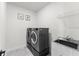 Functional laundry area featuring a modern washer and dryer, plus a utility sink at 7500 Alpine Butterfly Ln, Orlando, FL 32819