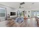 Open concept living room with wood floors, ceiling fan, and modern decor at 7500 Alpine Butterfly Ln, Orlando, FL 32819