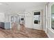 Spacious living area with wood floors, a modern light fixture, and views of the kitchen and outdoor space at 7500 Alpine Butterfly Ln, Orlando, FL 32819