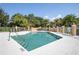Refreshing community pool surrounded by a white fence, palm trees, and manicured landscaping at 7628 Bay Port Rd # 43, Orlando, FL 32819