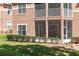 A ground-level exterior view reveals the building's architecture and the adjacent lawn area at 7628 Bay Port Rd # 43, Orlando, FL 32819