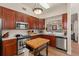 Kitchen features stainless appliances, granite countertops, and cherry cabinets, opening to the living room at 7628 Bay Port Rd # 43, Orlando, FL 32819