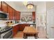 Well-lit kitchen featuring stainless appliances, cherry cabinets, and an island; view to the living room at 7628 Bay Port Rd # 43, Orlando, FL 32819