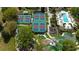 Aerial view of multiple tennis courts, swimming pool, playground and a mini golf course with lush landscaping at 812 Driving Range Ct, Reunion, FL 34747