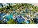 Aerial view of the swimming pools and tropical landscaping and blue sun umbrellas for rest and relaxation at 812 Driving Range Ct, Reunion, FL 34747