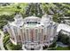 Stunning aerial view of a luxury condo building with a rooftop pool overlooking a lush golf course and community at 812 Driving Range Ct, Reunion, FL 34747